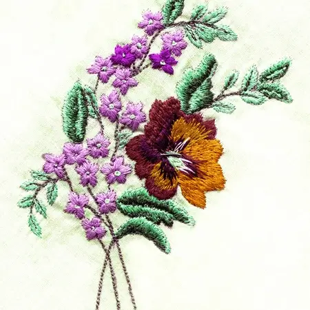 A close-up view of The Apparel Artist's impeccable custom high quality embroidery process, showcasing a vibrant design meticulously stitched onto a fabric.