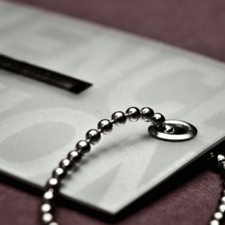 A close-up image of white hangtags with silver eyelets attached to it.